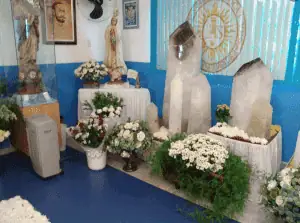 Vibrant altar with religious statues, flowers, and sacred stones, symbolizing divine energy and healing power, representative of distance energy healing practices and spiritual connection.