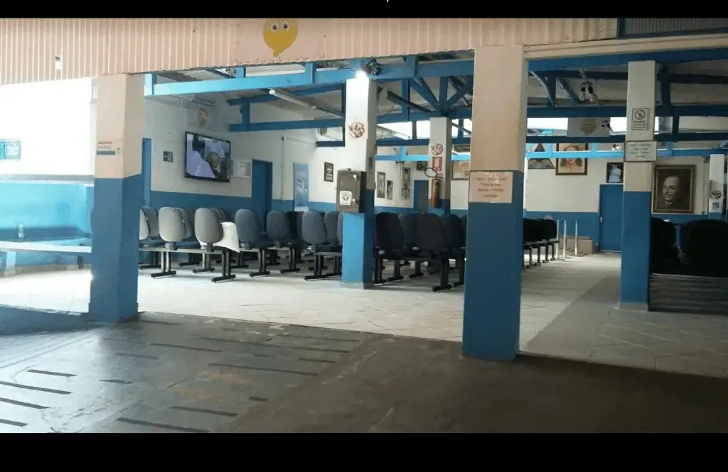 Waiting area with blue and white chairs at a bus station or terminal for distance energy healing sessions or consultations, featuring a cozy, well-lit environment with artwork and informational posters on the walls.